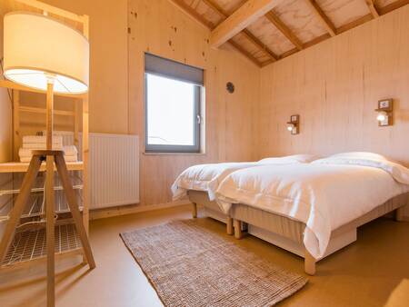 Bedroom with a double bed of a holiday home at the Landal Marker Wadden holiday park