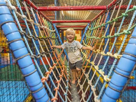 Child plays in the indoor playground of holiday park Landal Mooi Zutendaal