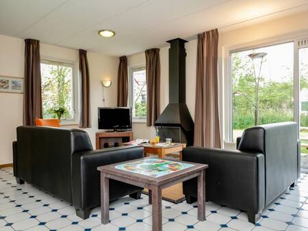 Living room with fireplace of a holiday home at the Landal Nature Village Suyderoogh holiday park