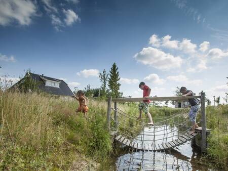 Children walk over a bridge of the nature experience trail at the Landal Orveltermarke holiday park
