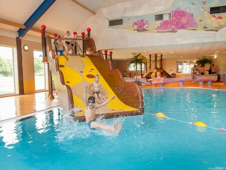Children slide down the wide slide into the swimming pool at the Landal Orveltermarke holiday park
