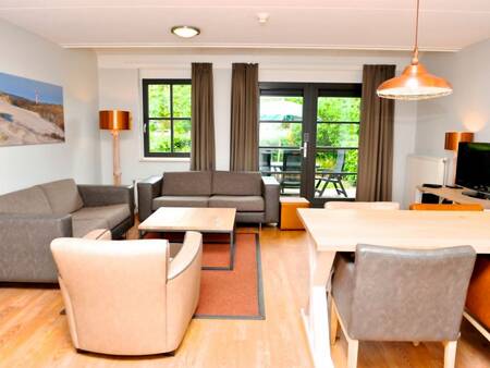 Living room with dining area of an apartment at Landal Residence 't Hof van Haamstede