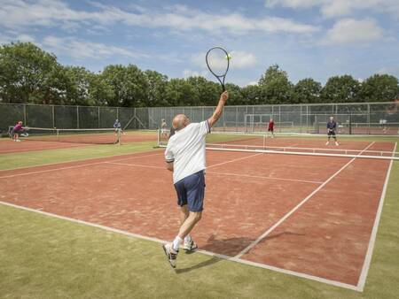 A game of tennis on the tennis court next to holiday park Landal Resort Haamstede