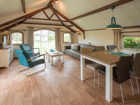 Dining area and living room of a holiday home at Landal Schuttersbos holiday park