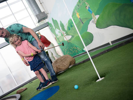 A game of mini golf on the mini golf course of holiday park Landal Seawest