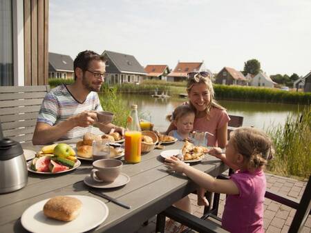 A family eats in the garden at holiday park Landal Strand Resort Nieuwvliet-Bad