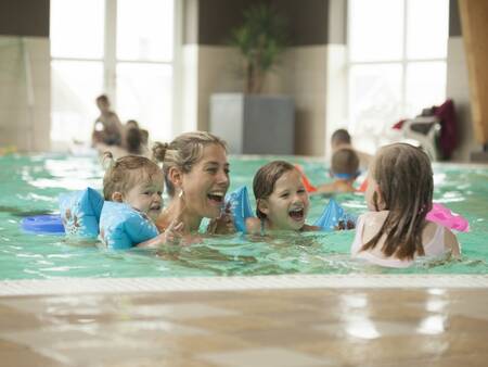 People swim in the swimming pool of holiday park Landal Strand Resort Nieuwvliet-Bad