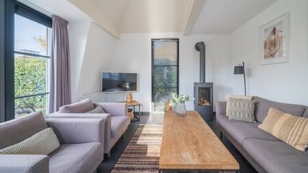 Living room with wood stove of a holiday home at Landal Holiday Park Duynvallei