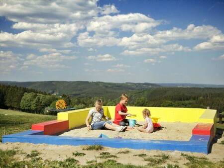 Children play in the sandbox in the playground at the Landal Village les Gottales holiday park