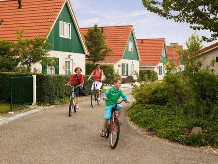 Family cycles between the holiday villas at the Landal Villapark Livingstone holiday park