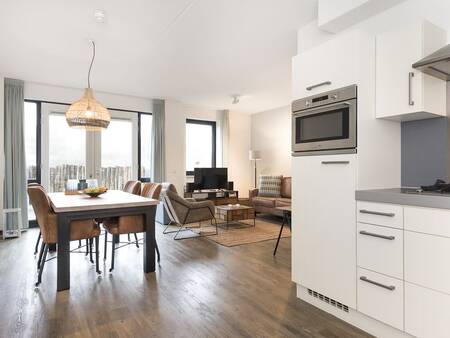 Kitchen, dining table and living room of an apartment at Landal Vitamaris