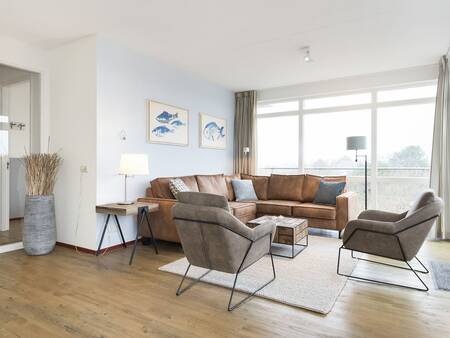 Living room with large windows of an apartment at Landal Vitamaris on Schiermonnikoog