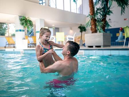 Father and daughter swim in the indoor pool of Landal Vitamaris