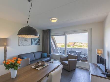 Dining area, living room and balcony of an apartment at Landal Vlieduyn