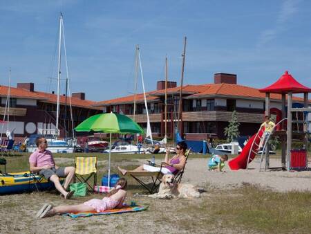 Sunbathing lawn and playground at Landal Waterparc Veluwemeer holiday park