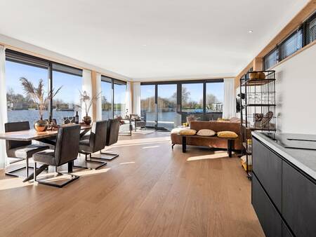 Living room with kitchen of a water house at holiday park Landal Waterpark De Alde Feanen