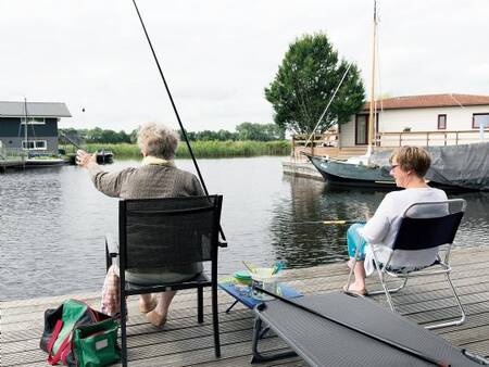 Man fishes from the jetty at his holiday home at the Landal Waterpark Sneekermeer holiday park