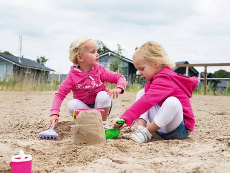 Children play in the sand on the recreational beach of holiday park Landal Waterpark Sneekermeer