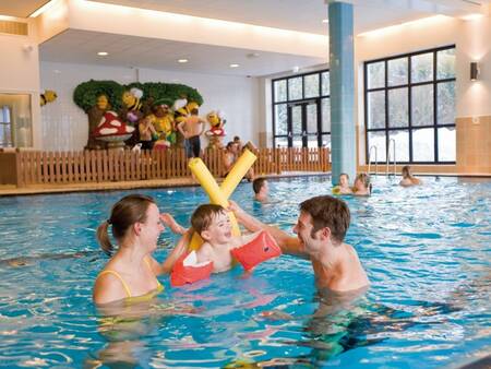 A family plays in the water of the swimming pool of the Landal Winterberg holiday park