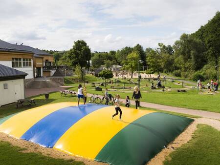 Children jump on the air trampoline in the playground of the Landal Wirfttal holiday park