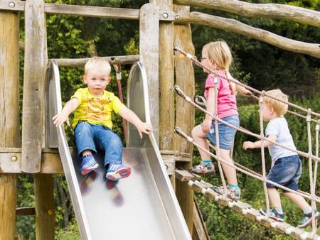 Children on a playground equipment in a playground at holiday park Landal Wirfttal