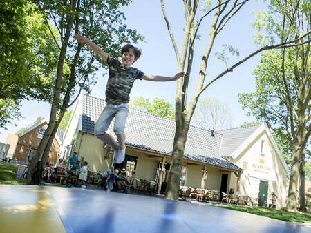 Child jumps on the air trampoline in the playground of holiday park Landal de Waufsberg