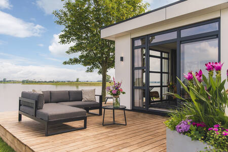 Lounge set on a jetty of a holiday home on the water at MarinaPark Bad Nederrijn