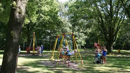 Children play in a large playground at holiday park Molecaten Bosbad Hoeven