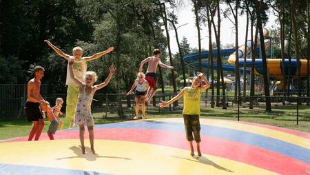Children jump on the air trampoline in a playground at holiday park Molecaten Bosbad Hoeven