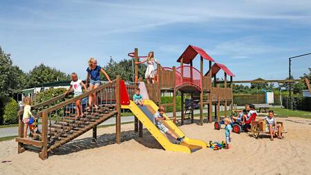 Children play in a playground at holiday park Molecaten Hoogduin