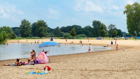 People on the beach at the Agnietenplas at holiday park Molecaten Park De Agnietenberg