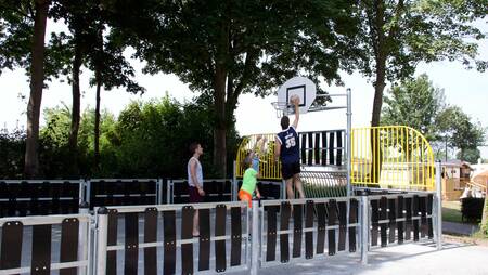 Children playing on the playing field of holiday park Molecaten Park De Agnietenberg