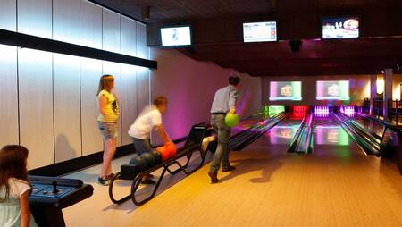 Family bowling on the bowling alley of holiday park Molecaten Park De Koerberg