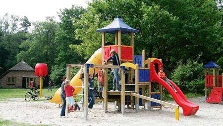 Children play in a playground at holiday park Molecaten Park De Leemkule