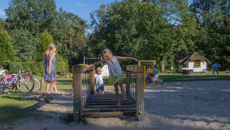 Children play in the playground of holiday park Molecaten Park De Leemkule