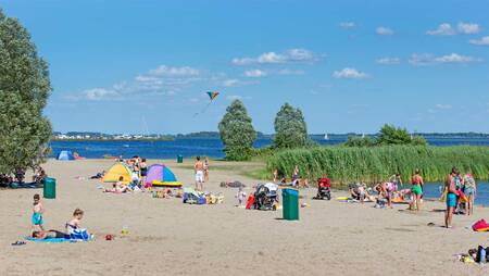 People on the beach at Lake Veluwe at holiday park Molecaten Park Flevostrand