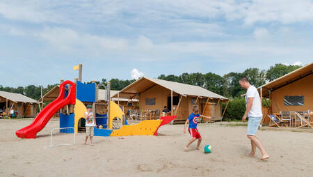 Safari tents around a playground at holiday park Molecaten Park Flevostrand