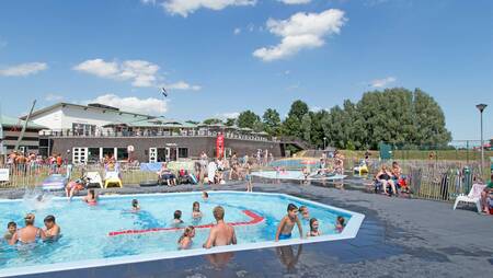 People swimming in the outdoor pool of holiday park Molecaten Park Flevostrand