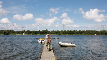 Grandpa with boy on a jetty on Lake Brielse at holiday park Molecaten Park Kruininger Gors