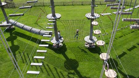 People climbing in the climbing park at holiday park Molecaten Park Kuierpad