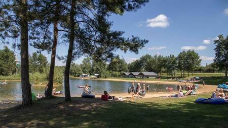People on the beach of the recreational lake at holiday park Molecaten Park Kuierpad