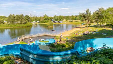 People on the outdoor slide that ends in the lake at holiday park Molecaten Park Kuierpad