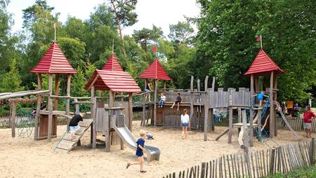 Children playing in a large playground at holiday park Molecaten Park Landgoed Ginkelduin