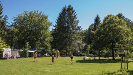 Children play on the playing field between the caravans at the Park Landgoed Molecaten holiday park