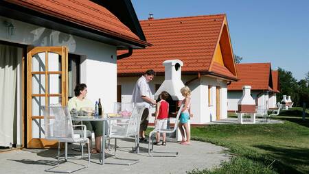 People in the garden of a holiday home at holiday park Molecaten Park Legénd Estate