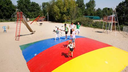 Children jump on the air trampoline in a playground at holiday park Molecaten Park Rondeweibos