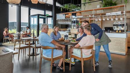 People eating in the restaurant of the Molecaten Park Waterdunen holiday park