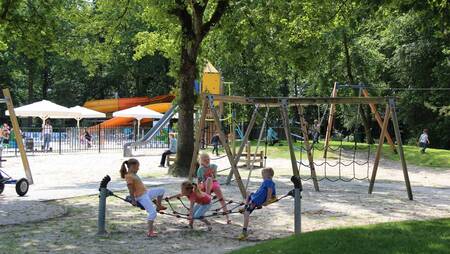 Children play in a large playground at holiday park Molecaten Park 't Hout