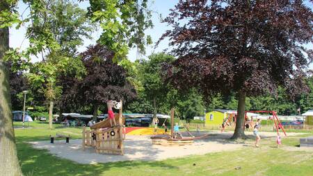 Children play in a playground between the chalets at the Molecaten Waterbos holiday park