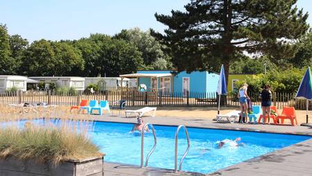 People swimming in the outdoor pool of holiday park Molecaten Waterbos